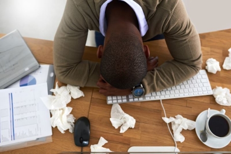 man with allergies at office desk